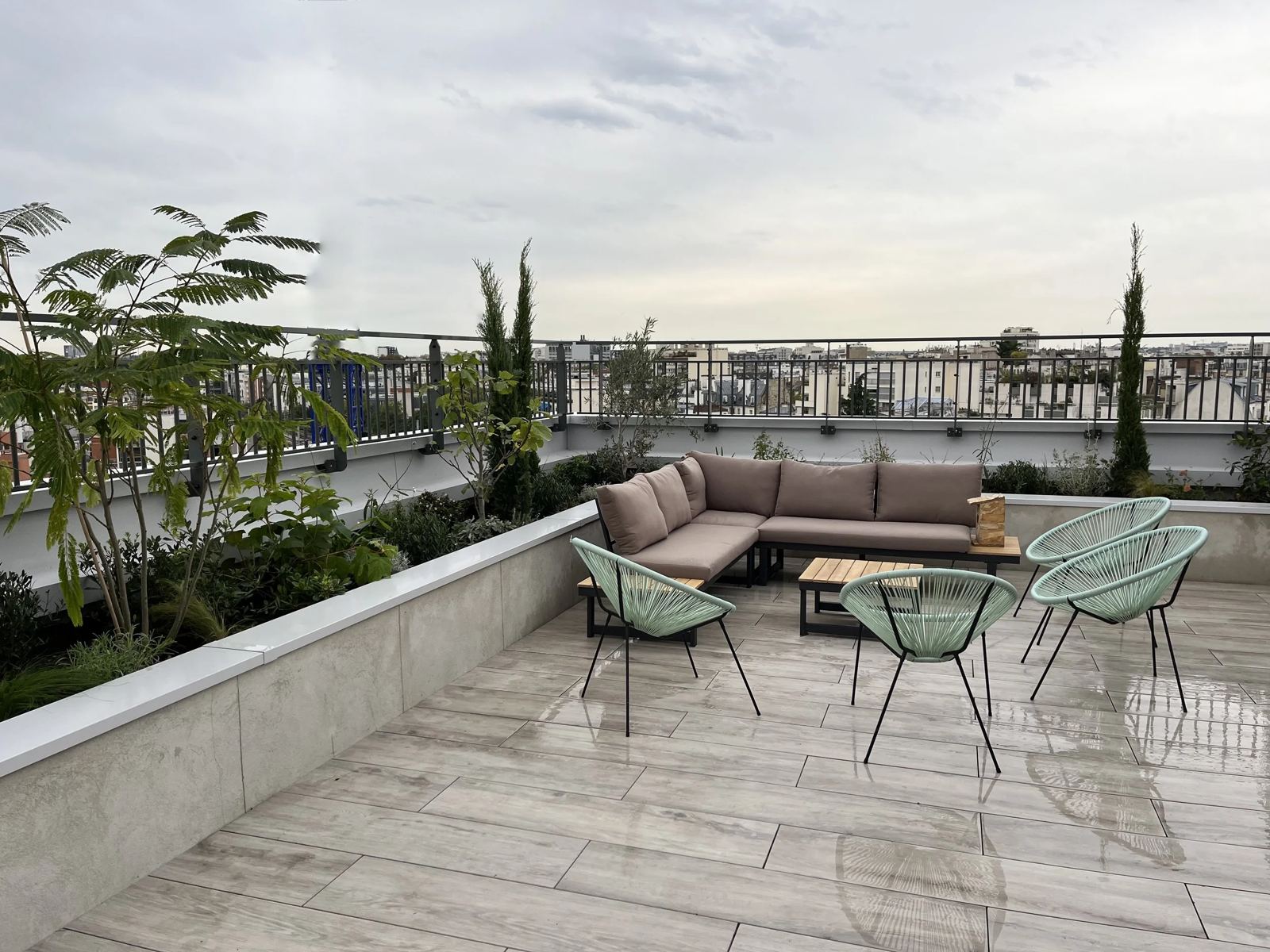 Toit-terrasse de Denfert : banquette et jardinières sur fond de toits parisiens