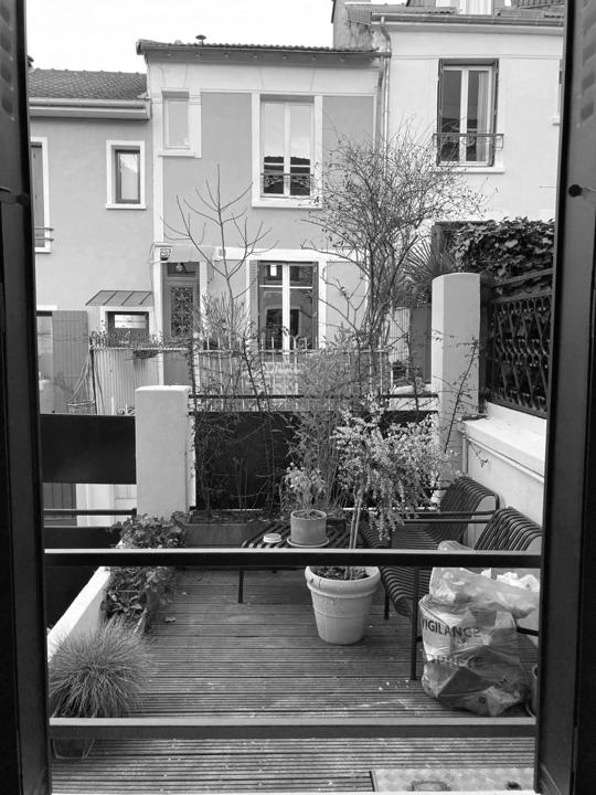 La terrasse avant les travaux : plancher nu, quelques pots, vue dégagée sur les maisons voisines